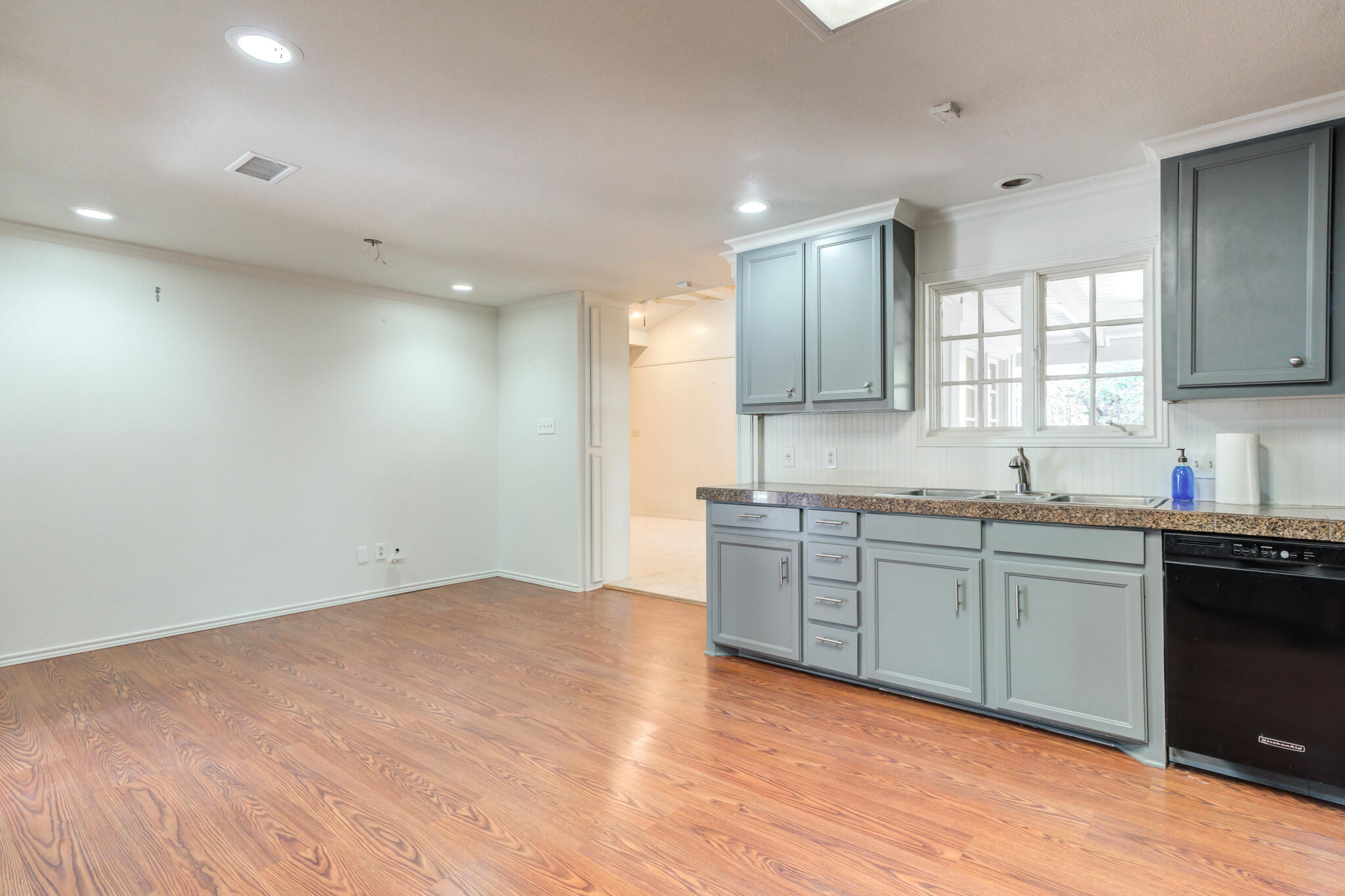 4629 88th Street Lubbock, TX 79424 - Photo 21 of 60 a large kitchen with granite countertop a sink and dishwasher stove top oven with wooden floor