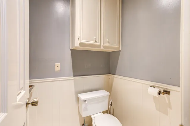 a bathroom with a granite countertop toilet sink and mirror