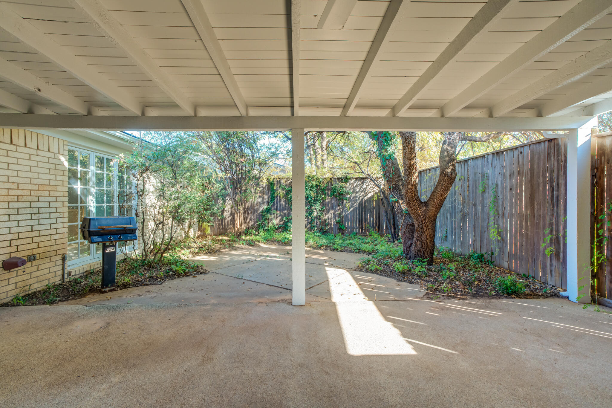 4629 88th Street Lubbock, TX 79424 - Photo 56 of 60 a view of a backyard with table and chairs and a large tree