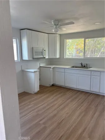 a large kitchen with kitchen island white cabinets and wooden floor