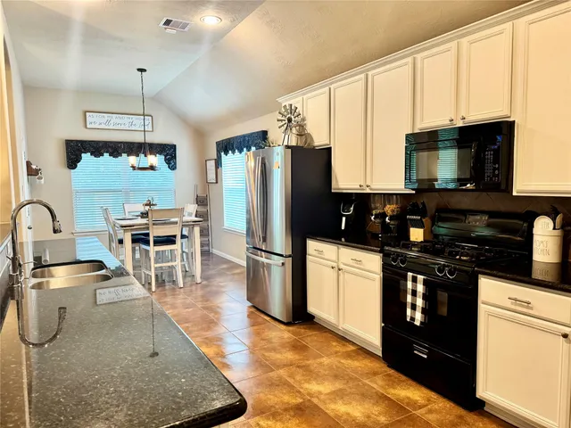 a open kitchen with stainless steel appliances granite countertop a stove a sink and a refrigerator