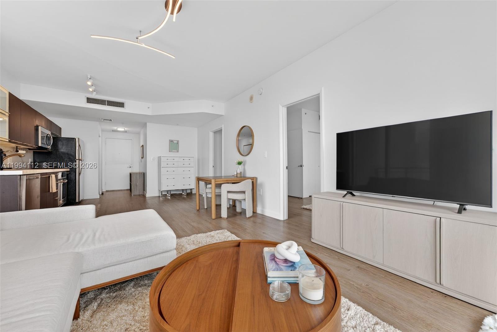 90 Southwest 3rd Street, Unit 1105 Miami, FL 33130 - Photo 6 of 11 a living room with furniture and a flat screen tv