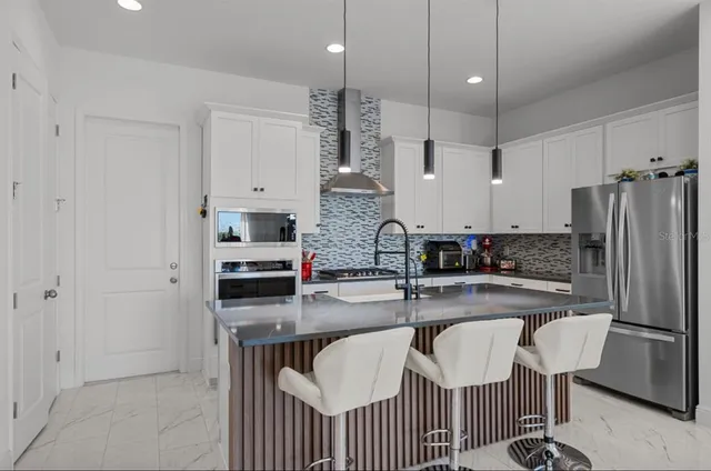 a kitchen with refrigerator and cabinets