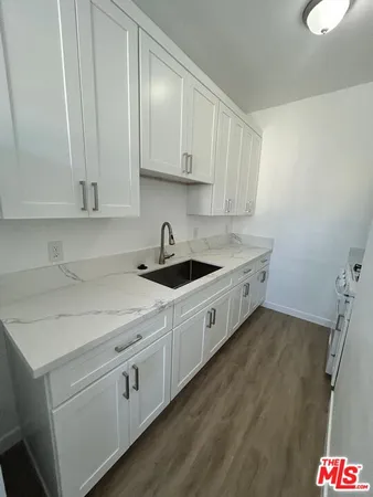 a kitchen with a sink a stove and cabinets