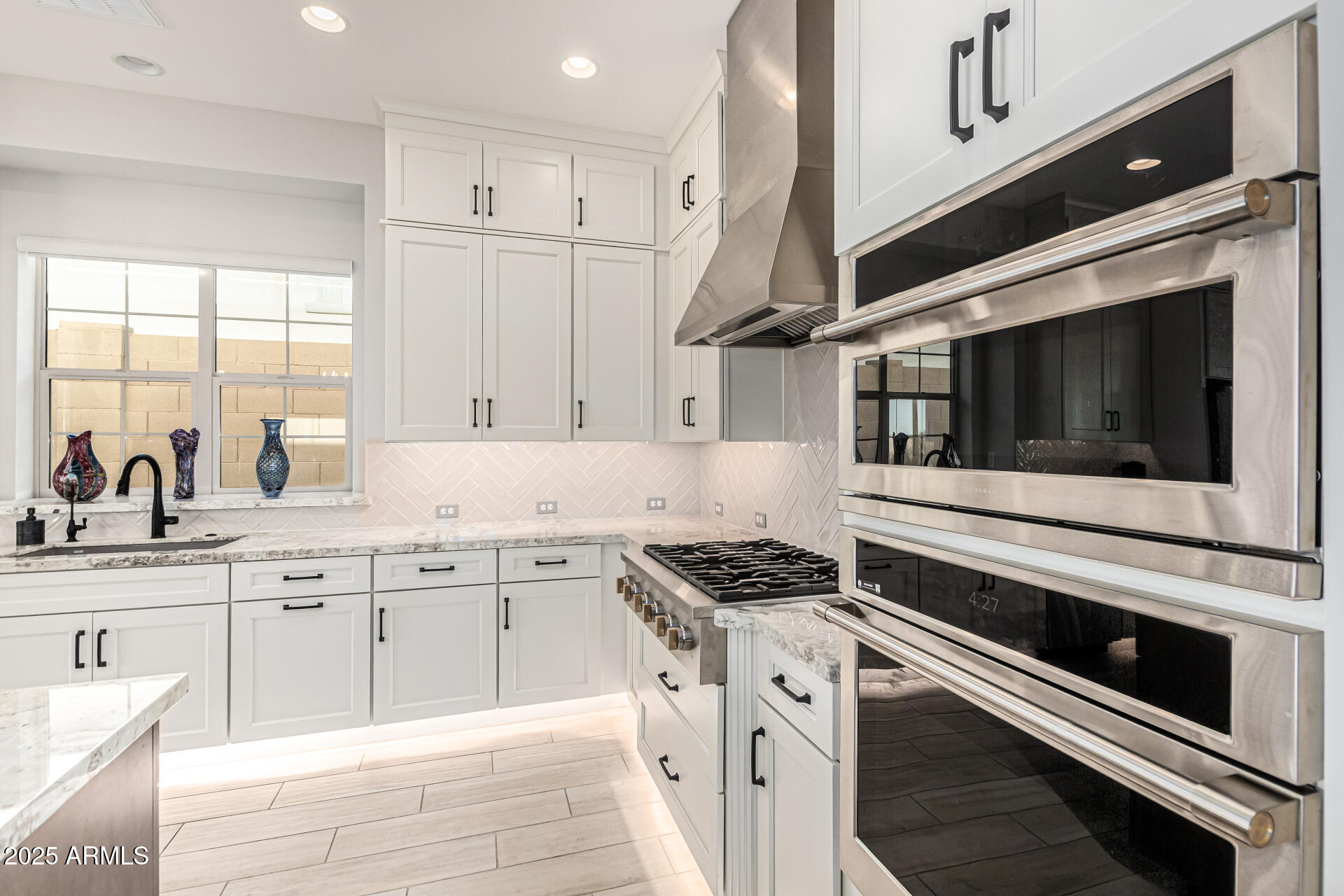 20709 West Rattler Road Buckeye, AZ 85396 - Photo 16 of 66 a kitchen with stainless steel appliances kitchen island granite countertop a stove and a sink