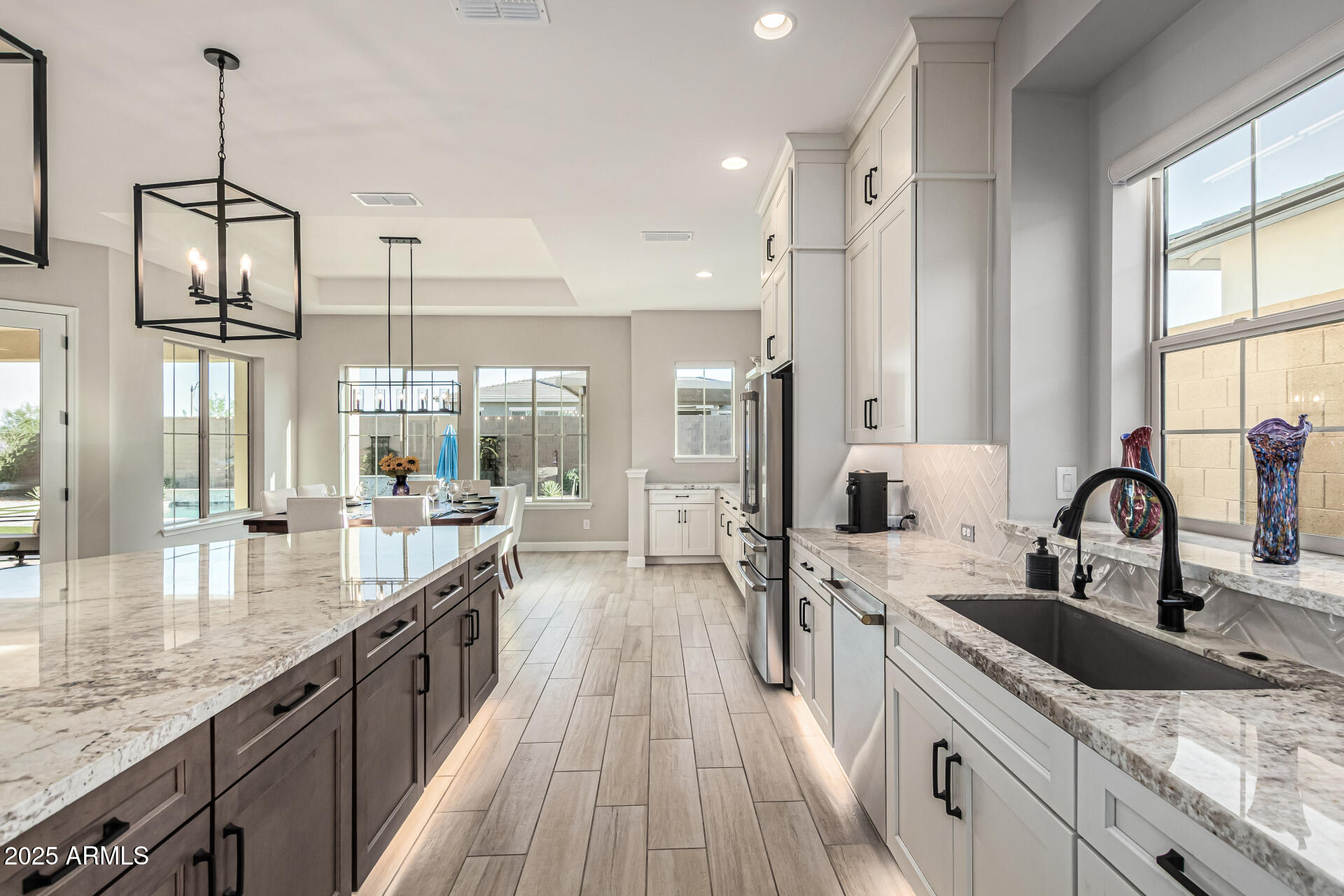 20709 West Rattler Road Buckeye, AZ 85396 - Photo 17 of 66 a large kitchen with kitchen island a large counter space a sink and stainless steel appliances