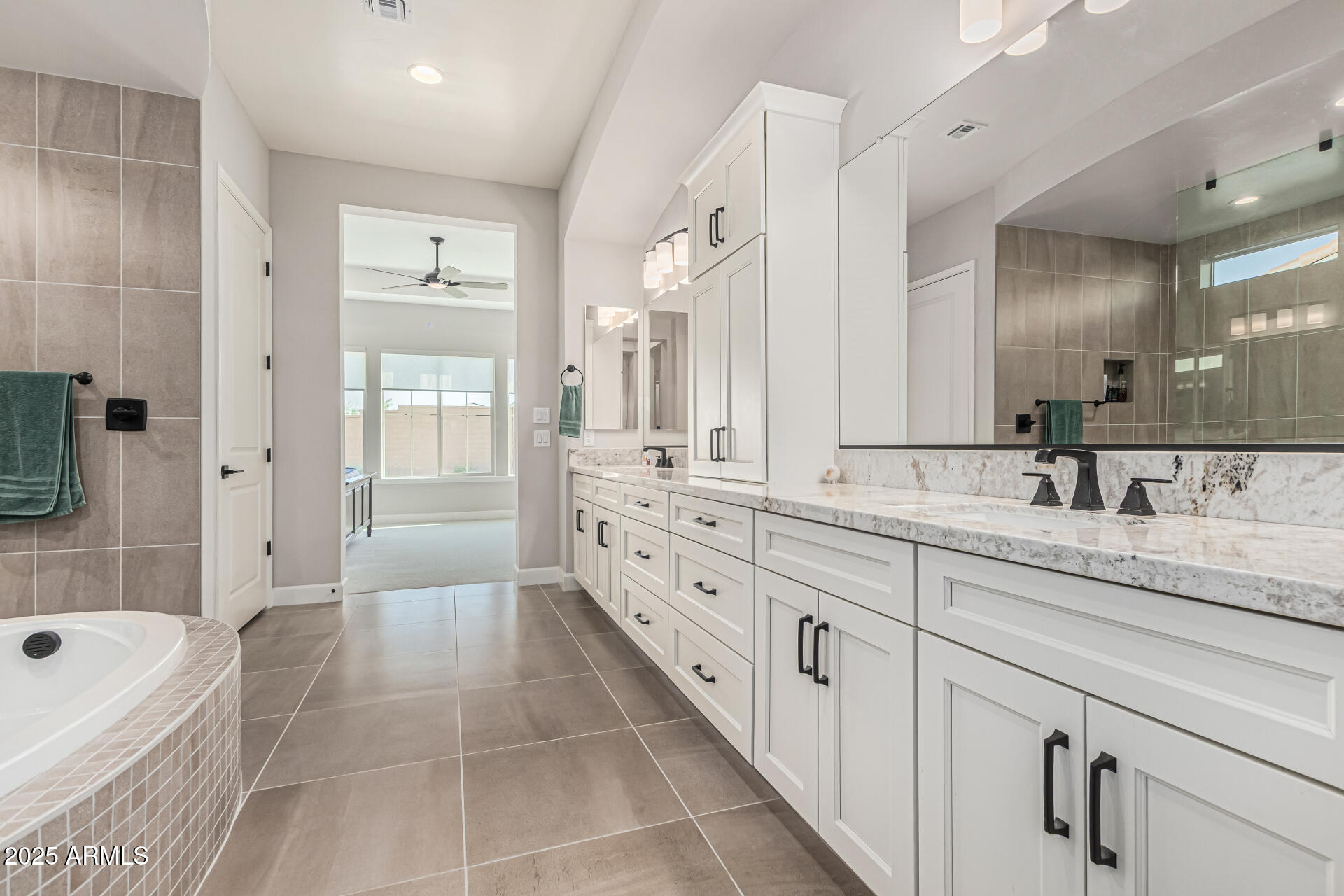 20709 West Rattler Road Buckeye, AZ 85396 - Photo 25 of 66 a spacious bathroom with a granite countertop sink a mirror a bathtub and shower