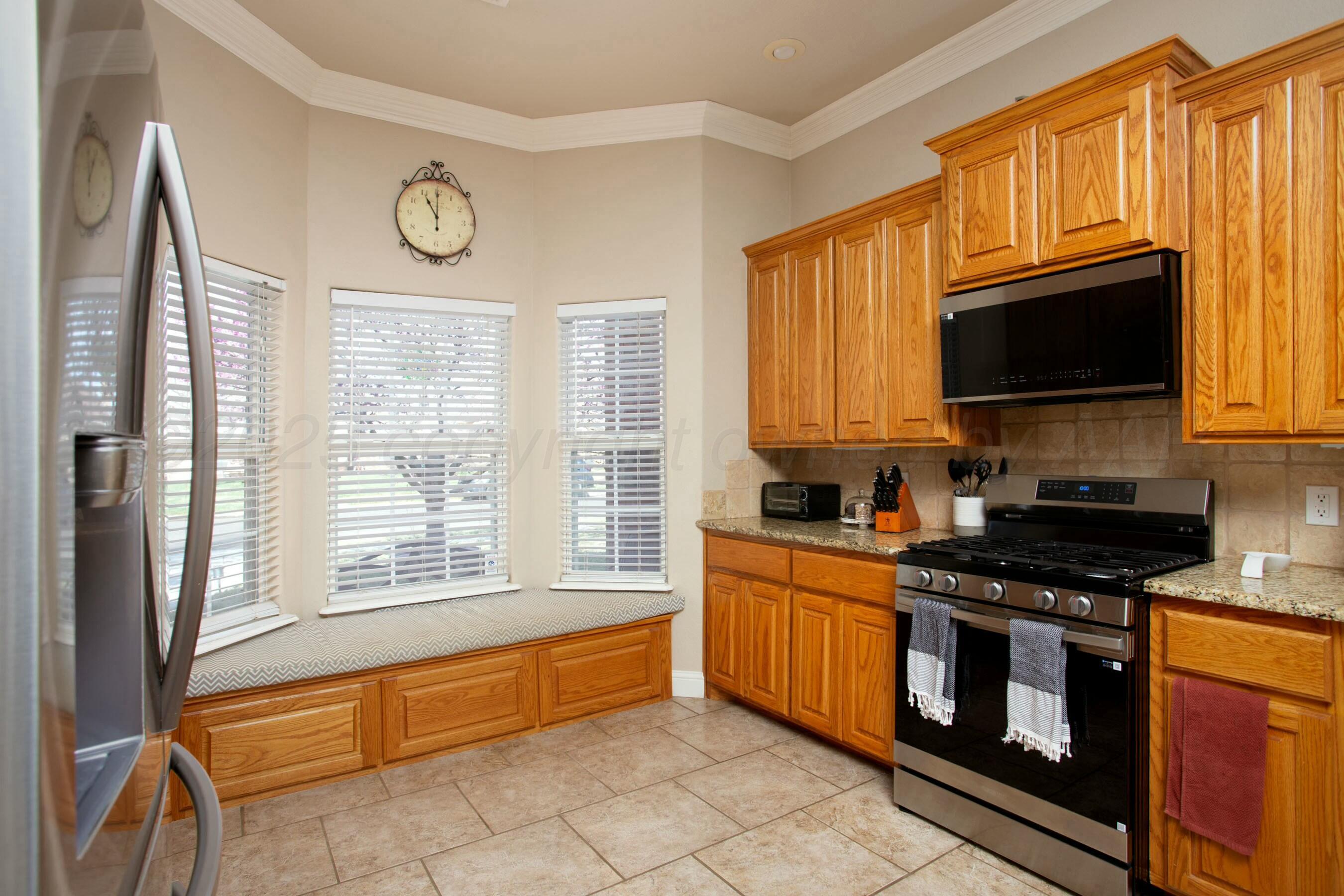 8103 El Paso Drive Amarillo, TX 79118 - Photo 7 of 40 a kitchen with granite countertop a stove a sink and a microwave