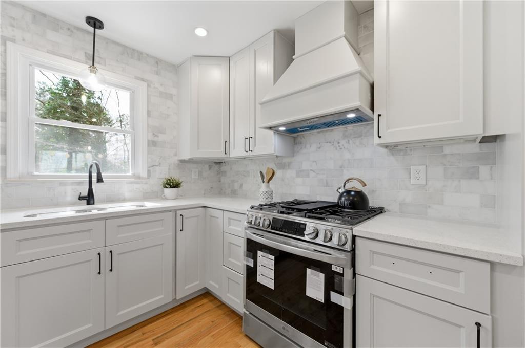 3571 Midvale Forest Court Tucker, GA 30084 - Photo 15 of 53 a kitchen with stainless steel appliances white cabinets and a stove top oven