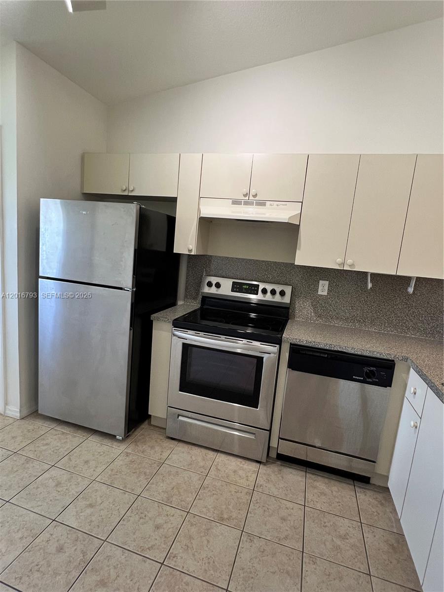 2931 Southeast 12th Road, Unit 20455 Homestead, FL 33035 - Photo 3 of 12 a kitchen with a stove a sink and a refrigerator