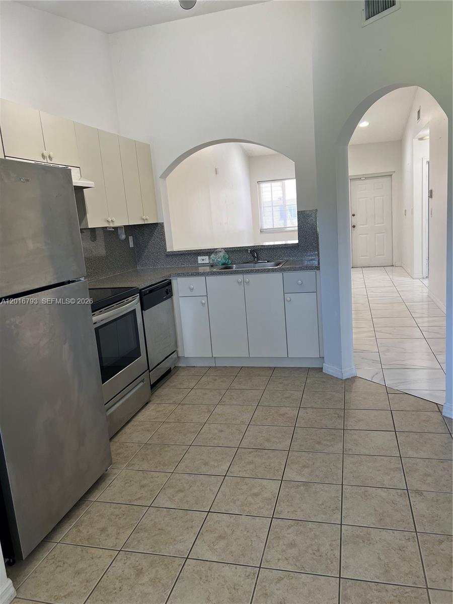 2931 Southeast 12th Road, Unit 20455 Homestead, FL 33035 - Photo 4 of 12 a kitchen with a sink a stove and cabinets