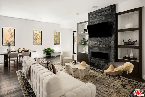 a living room with furniture a fireplace and a potted plant