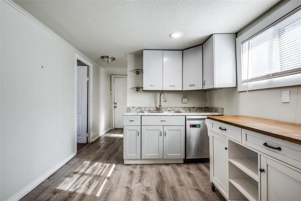 701 Lakey Street Denton, TX 76205 - Photo 13 of 25 a kitchen with granite countertop white cabinets stainless steel appliances a sink and a window