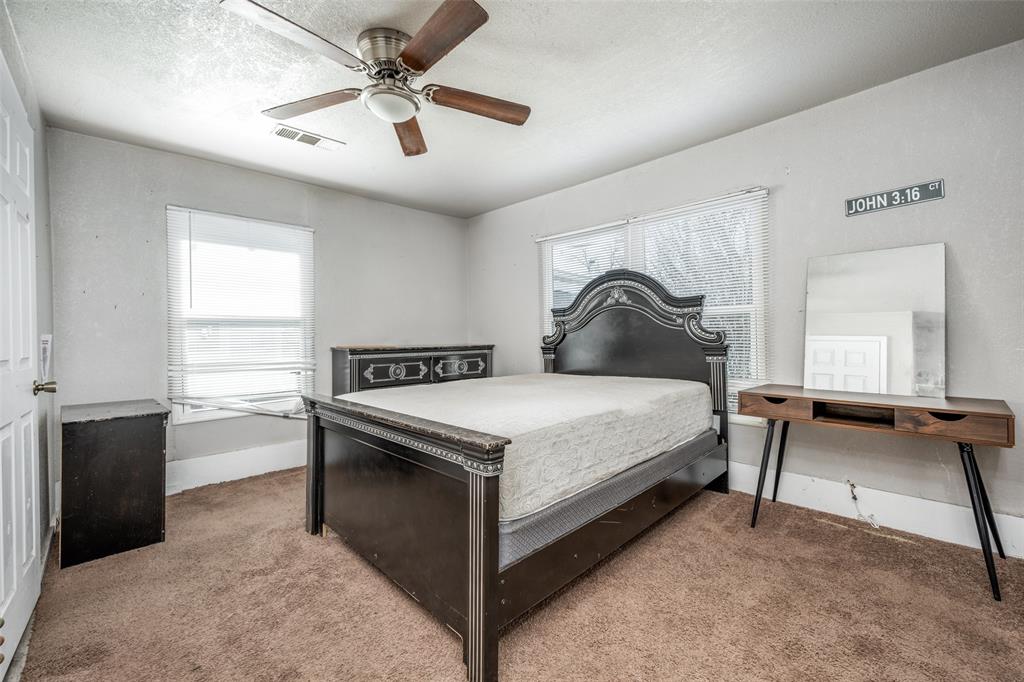701 Lakey Street Denton, TX 76205 - Photo 16 of 25 a bedroom with a bed and a chandelier