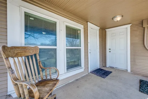 a view of a porch with a table and chairs