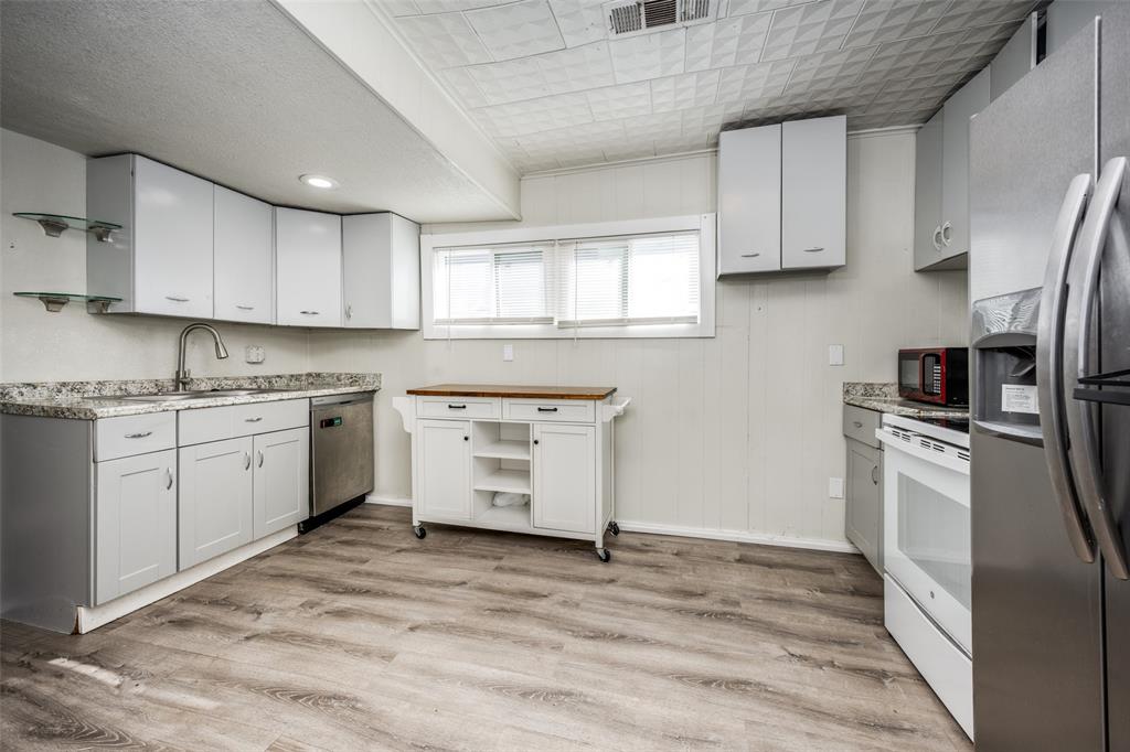 701 Lakey Street Denton, TX 76205 - Photo 10 of 25 a kitchen with a refrigerator stove top oven and cabinets
