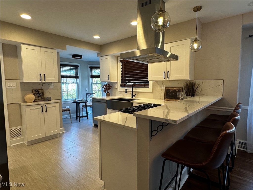 2255 Edgerton Road University Heights, OH 44118 - Photo 3 of 33 Kitchen with sink, island range hood, kitchen peninsula, and tasteful backsplash