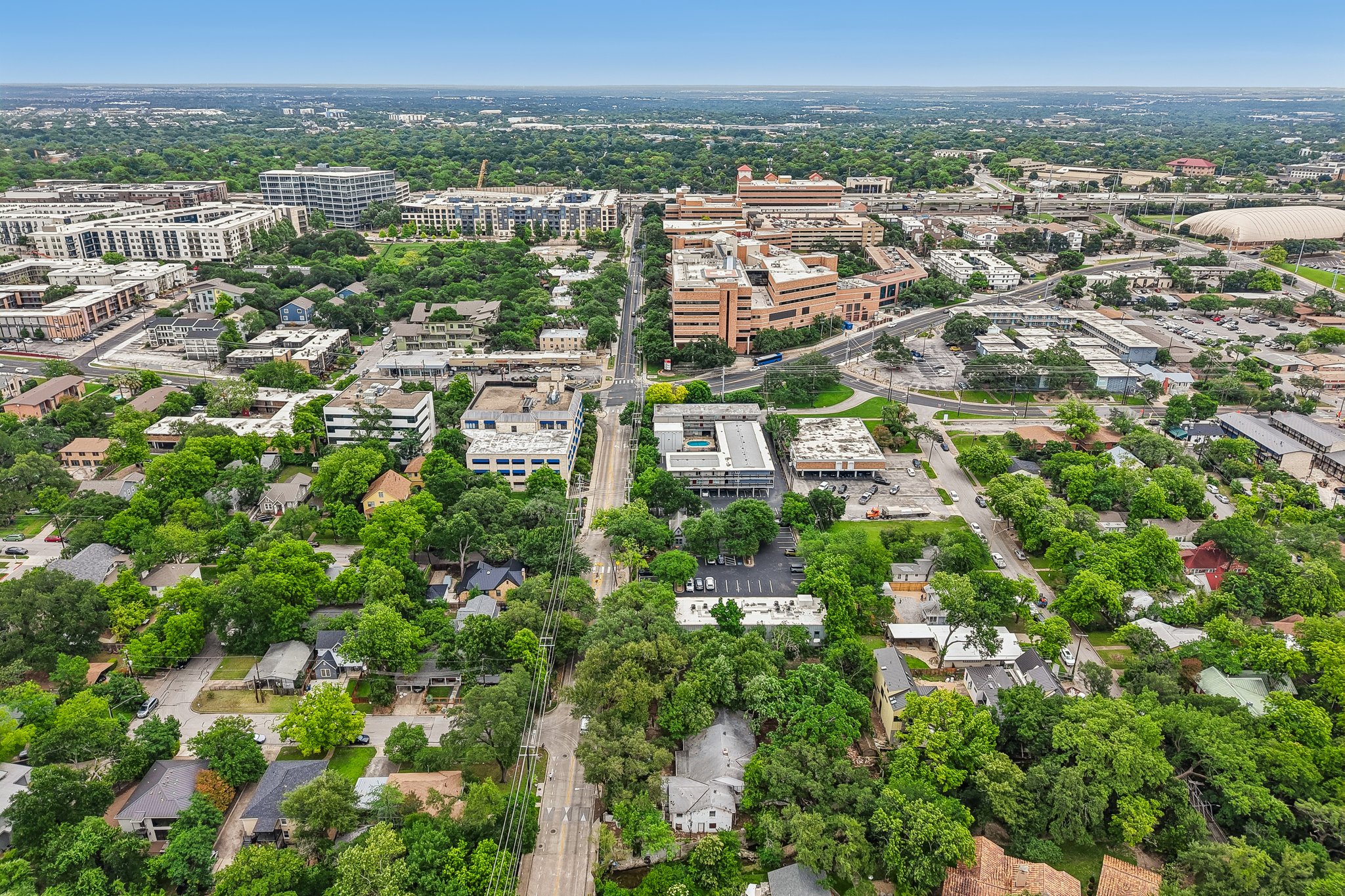801 East 32nd Street Austin, TX 78705 - Photo 13 of 13 An aerial panorama reveals a vibrant cityscape with lush green spaces and diverse architectural styles.