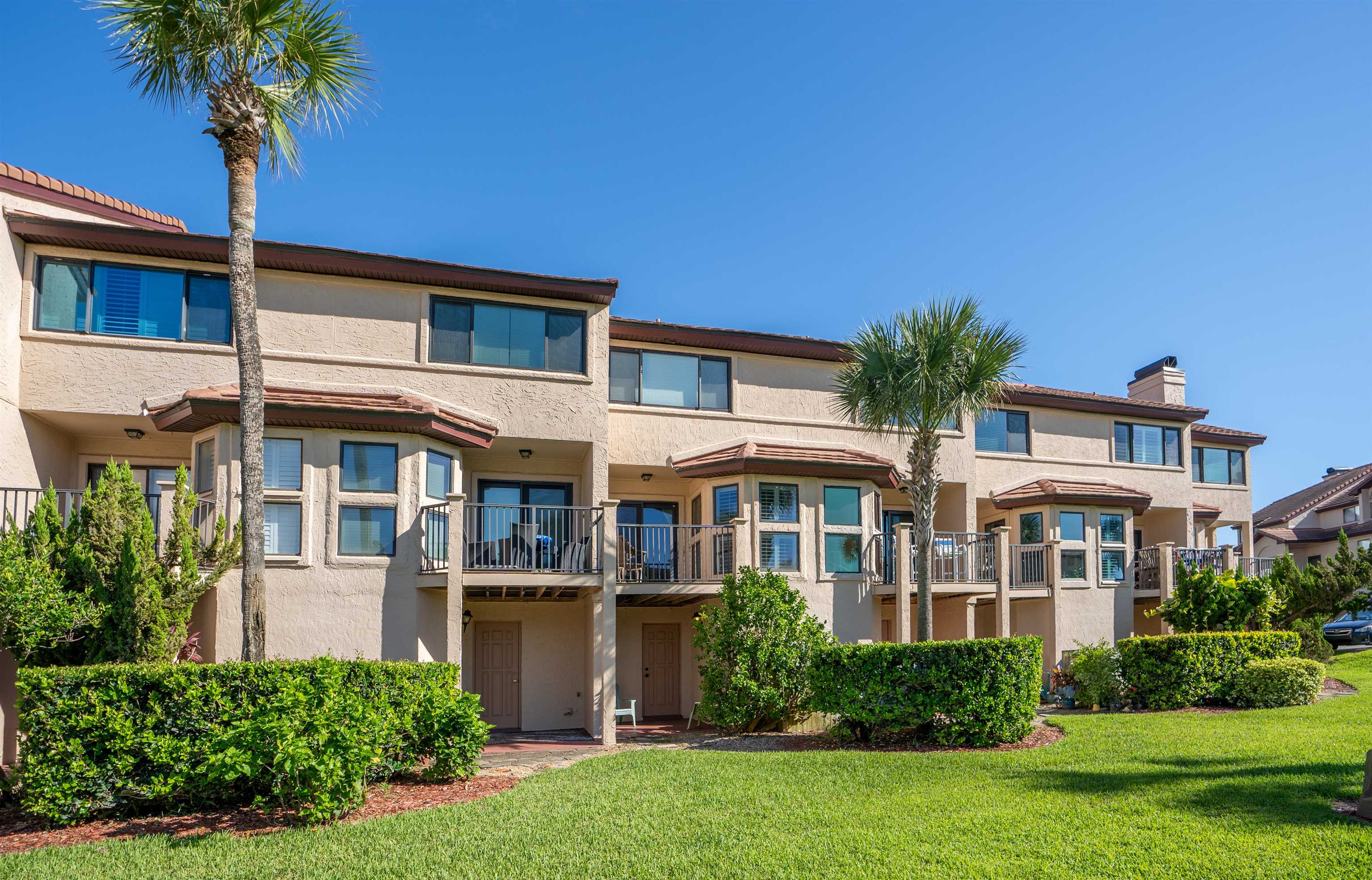 8200 A1A South, Unit 13 St. Augustine, FL 32080 - Photo 27 of 56 a front view of a house with a yard and potted plants