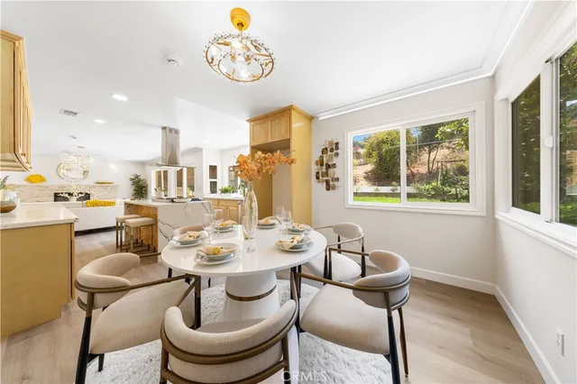 a kitchen with stainless steel appliances kitchen island granite countertop a sink a stove a dining table and chairs