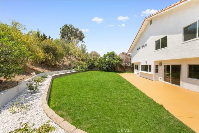 a white house with a big yard and big trees with a big yard