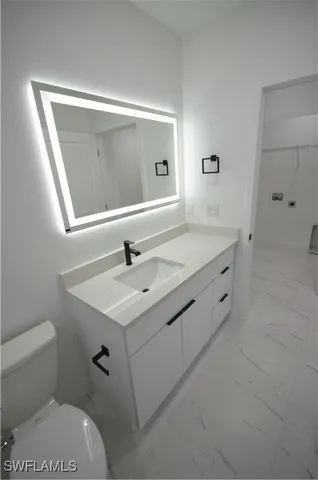 a bathroom with a sink toilet and mirror