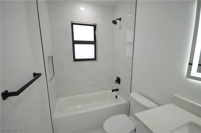 a bathroom with a toilet and a bath tub
