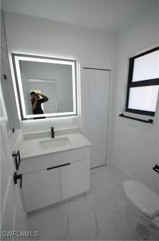 a bathroom with a sink a toilet and mirror