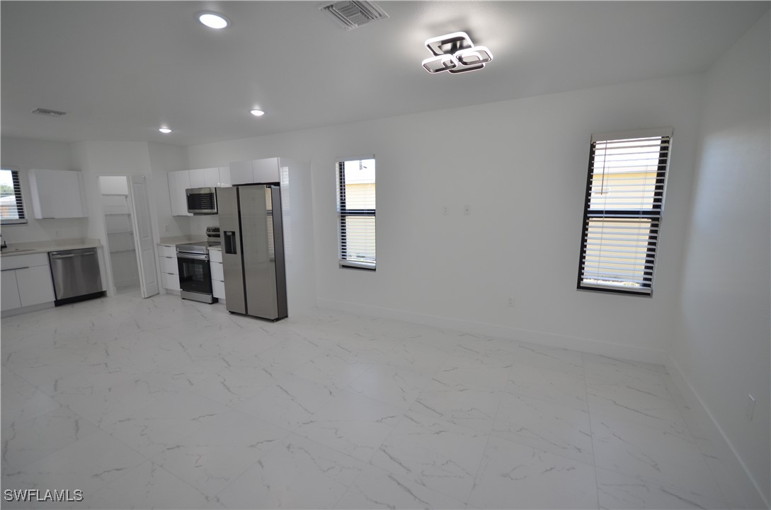 2132 Barker Boulevard Fort Myers, FL 33916 - Photo 3 of 36 an empty room with a windows and a chandelier