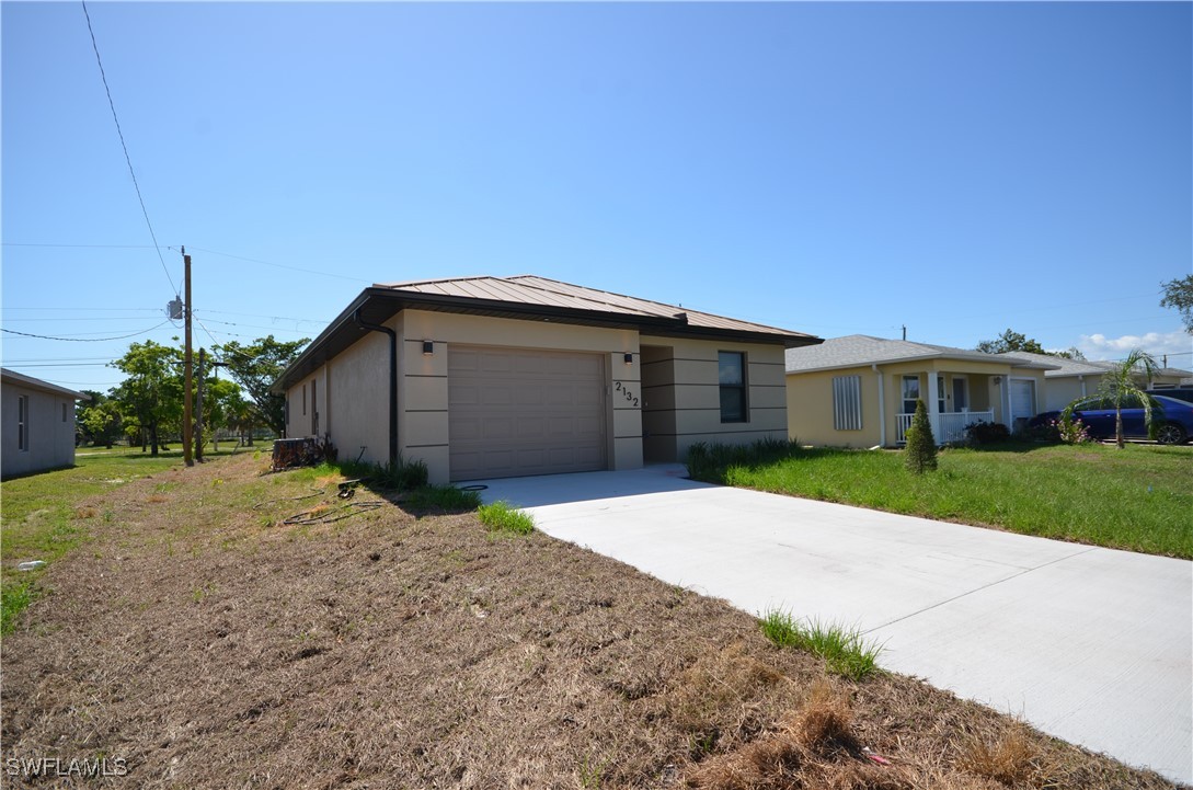 2132 Barker Boulevard Fort Myers, FL 33916 - Photo 33 of 36 a front view of a house with a yard and garage