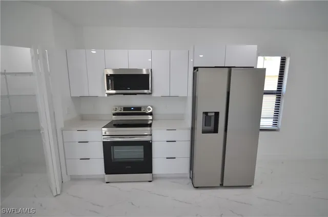 a kitchen with a refrigerator sink and cabinets