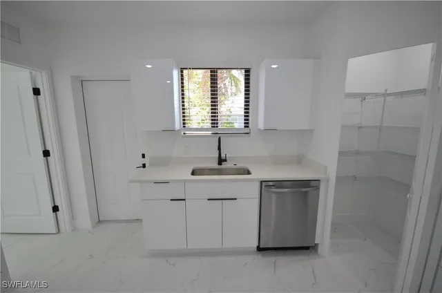 a kitchen with stainless steel appliances a sink a window and a refrigerator