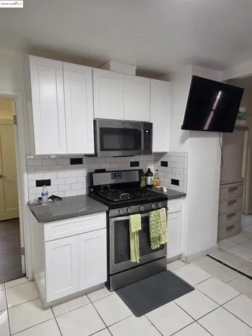 a kitchen with stainless steel appliances a stove a microwave a sink and cabinets
