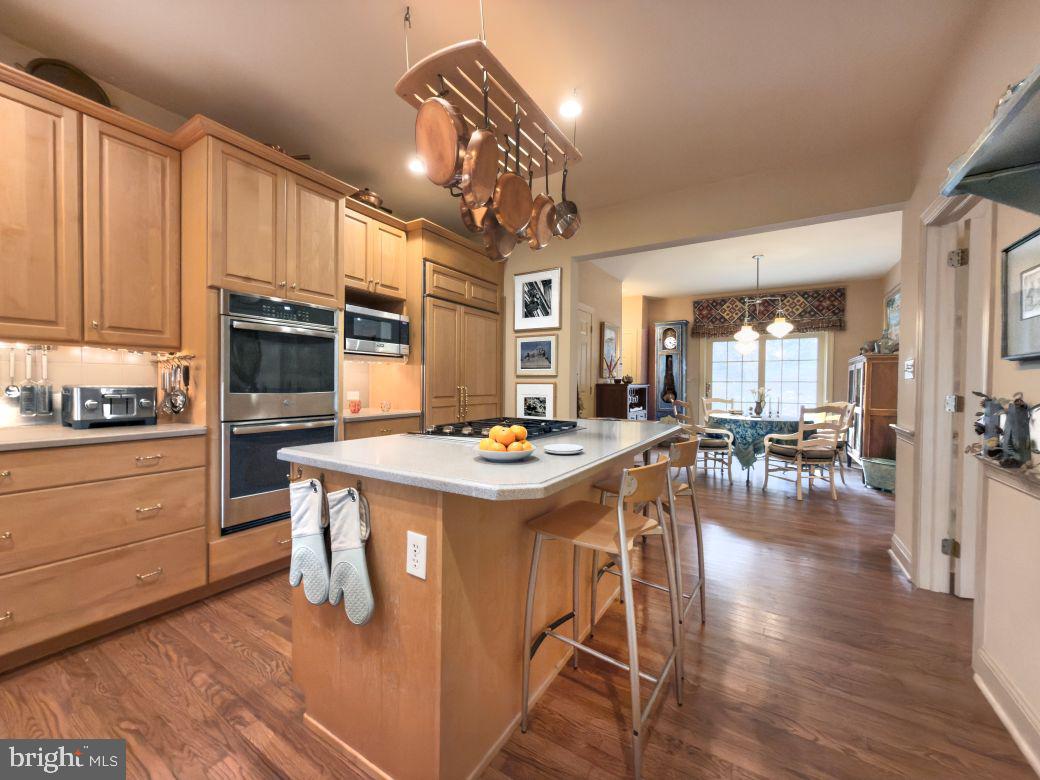 12 Chalous Lane Villanova, PA 19085 - Photo 16 of 39 a kitchen with stainless steel appliances granite countertop a stove refrigerator and a dining table with wooden floor