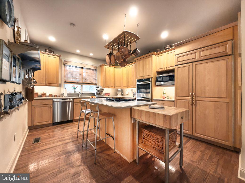 12 Chalous Lane Villanova, PA 19085 - Photo 17 of 39 a kitchen with kitchen island granite countertop wooden floors and stainless steel appliances