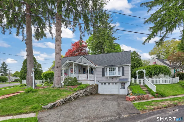 a view of house with a yard and potted plants