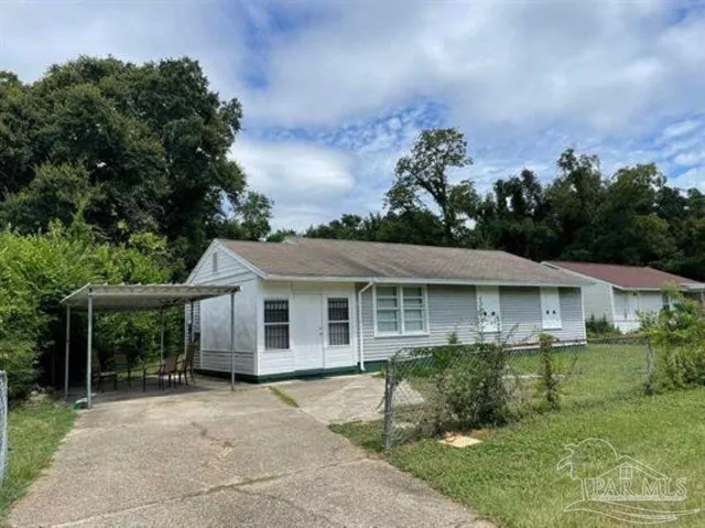 a view of a house with a yard and potted plants