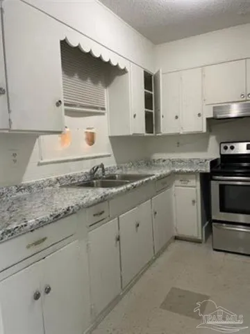 a kitchen with granite countertop white cabinets and white appliances