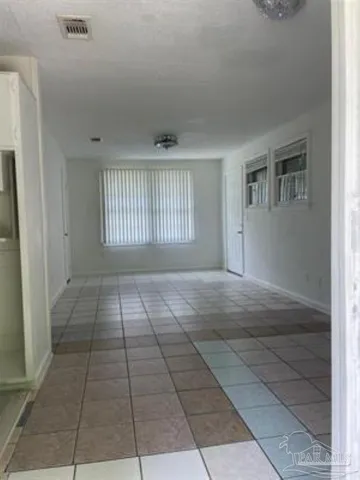 a view of a livingroom with an empty space and windows