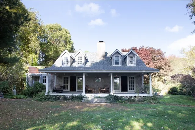 a view of a house with a yard and sitting area