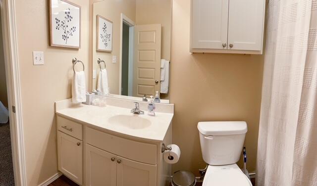 2116 10th Street Lubbock, TX 79401 - Photo 13 of 22 a bathroom with a toilet sink and mirror