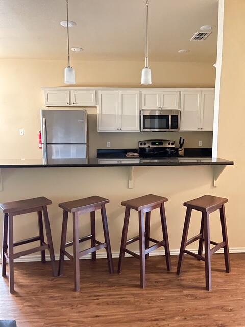 2116 10th Street Lubbock, TX 79401 - Photo 7 of 22 a kitchen with stainless steel appliances granite countertop a table chairs microwave and sink