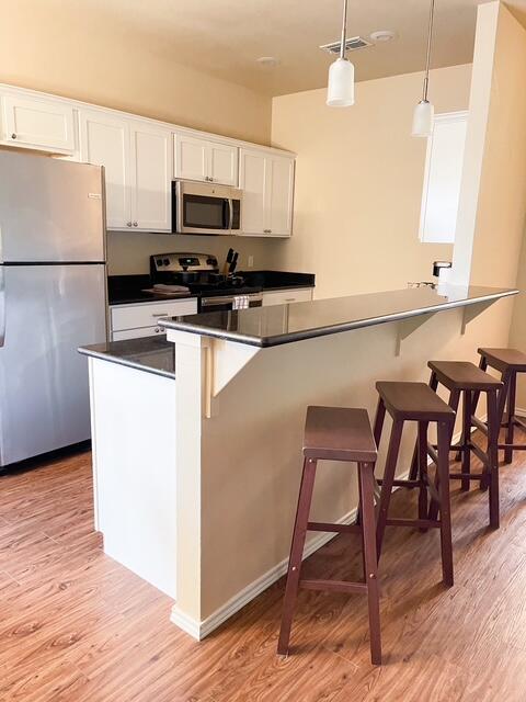 2116 10th Street Lubbock, TX 79401 - Photo 8 of 22 a kitchen with kitchen island a dining table chairs and a refrigerator