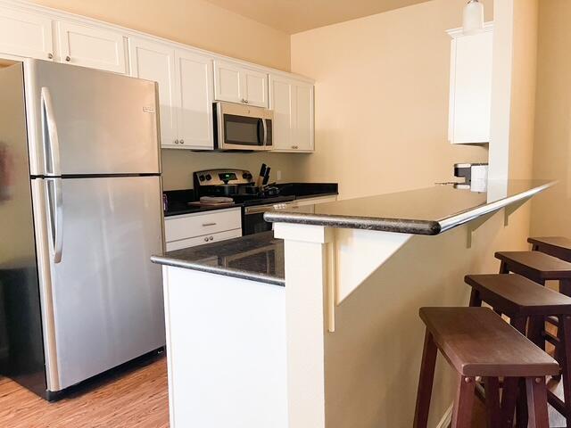 2116 10th Street Lubbock, TX 79401 - Photo 9 of 22 a kitchen with stainless steel appliances a refrigerator stove microwave and sink