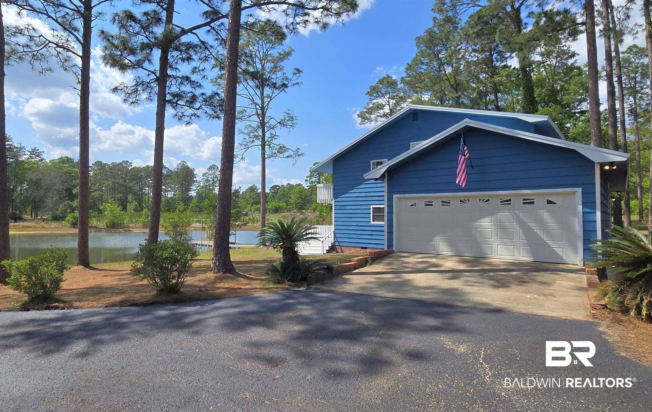 3160 Old Castleberry Road Brewton, AL 36426 - Photo 25 of 36 Blue siding exterior with an attached two-car garage, front driveway, and mature trees