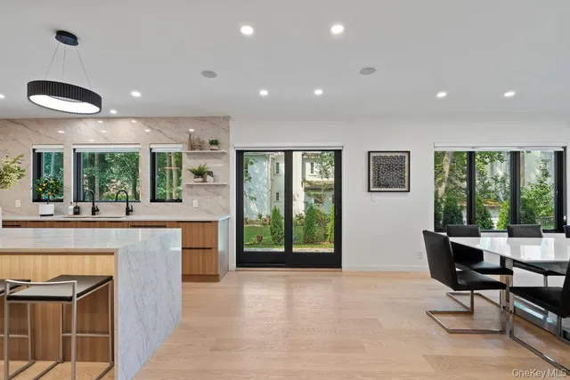 a open kitchen with kitchen island a large window a sink and a counter space
