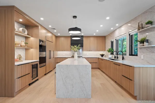 a large kitchen with stainless steel appliances kitchen island a large counter top a stove and a sink