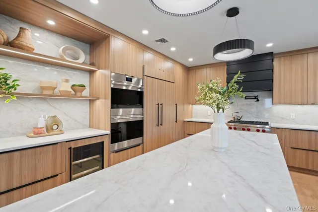 a large kitchen with stainless steel appliances a large counter top a stove and a refrigerator