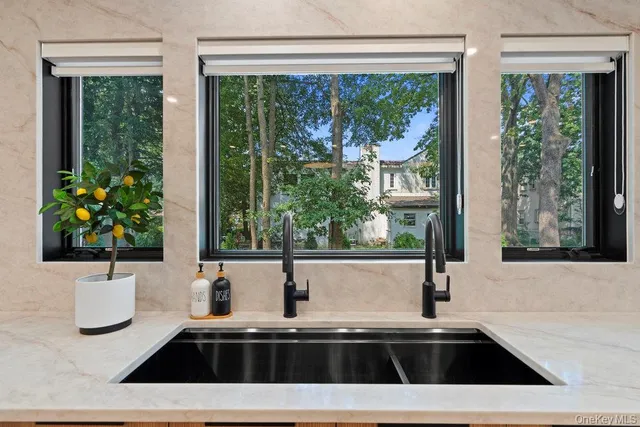 a kitchen with a sink a large window and a wooden floor