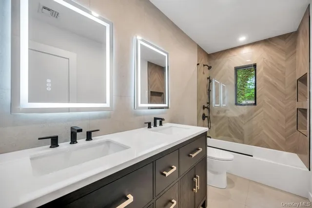 a bathroom with double sink and a mirror